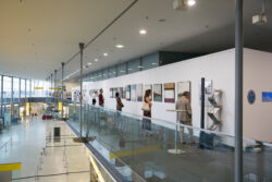Besucher:innen betrachten Kunstwerke der Ausstellung Ausstellungseröffnung von Evelyn Fasch in der Galerie am Flughafen Graz