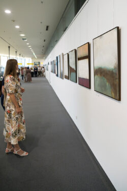 Besucherin betrachtet Kunstwerke der Ausstellung 