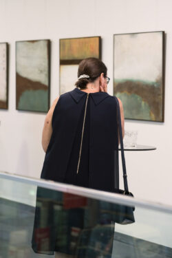 Besucherin beim Betrachten der Kunstwerke der Ausstellung Transformationen von Evelyn Fasch